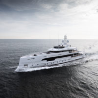 A large white luxury yacht cruising on a calm ocean under a cloudy sky.