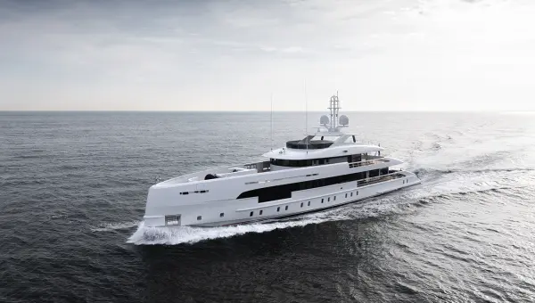 A large white luxury yacht cruising on a calm ocean under a cloudy sky.