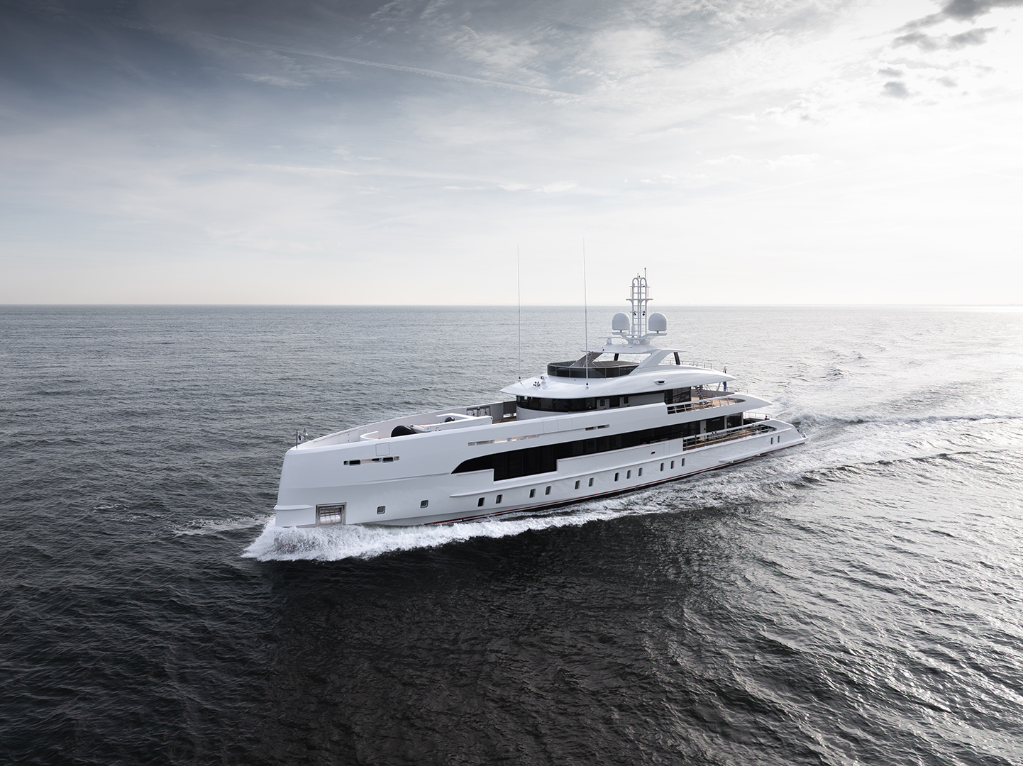 A large white luxury yacht cruising on a calm ocean under a cloudy sky.