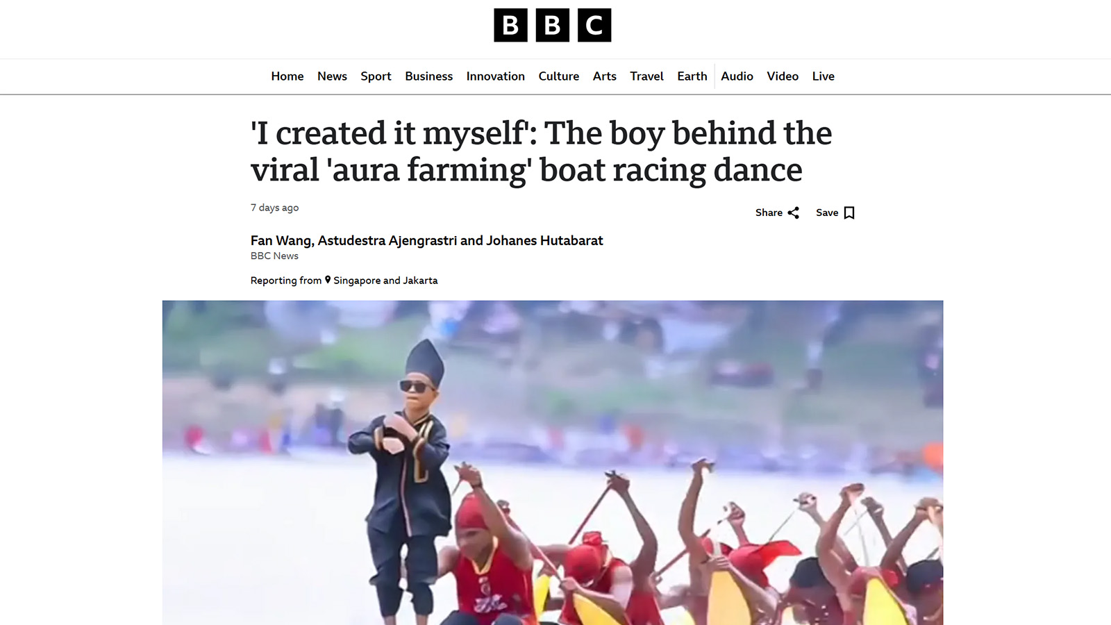 A young boy in sunglasses and traditional attire performing a dance in front of a group of people rowing in a boat, featured in a BBC News article.