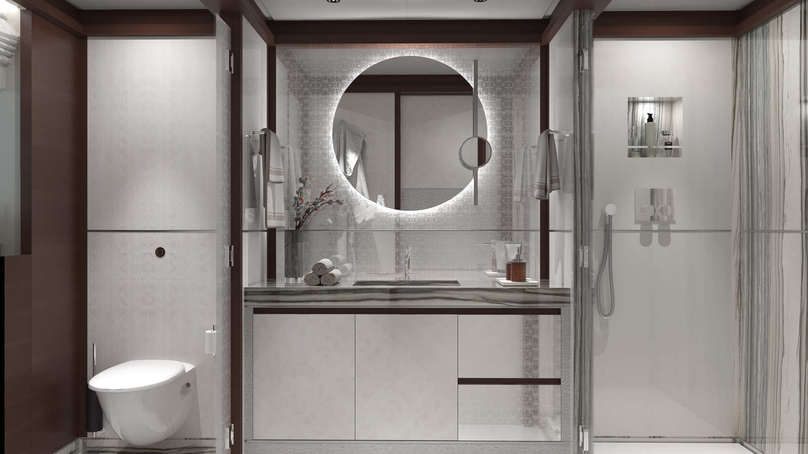 A modern bathroom interior featuring a circular illuminated mirror above a countertop with a sink and decorative elements, such as rolled towels and a small vase. On the left, there is a wall-mounted toilet, and on the right, a glass-enclosed shower area with a handheld shower and wall niche.