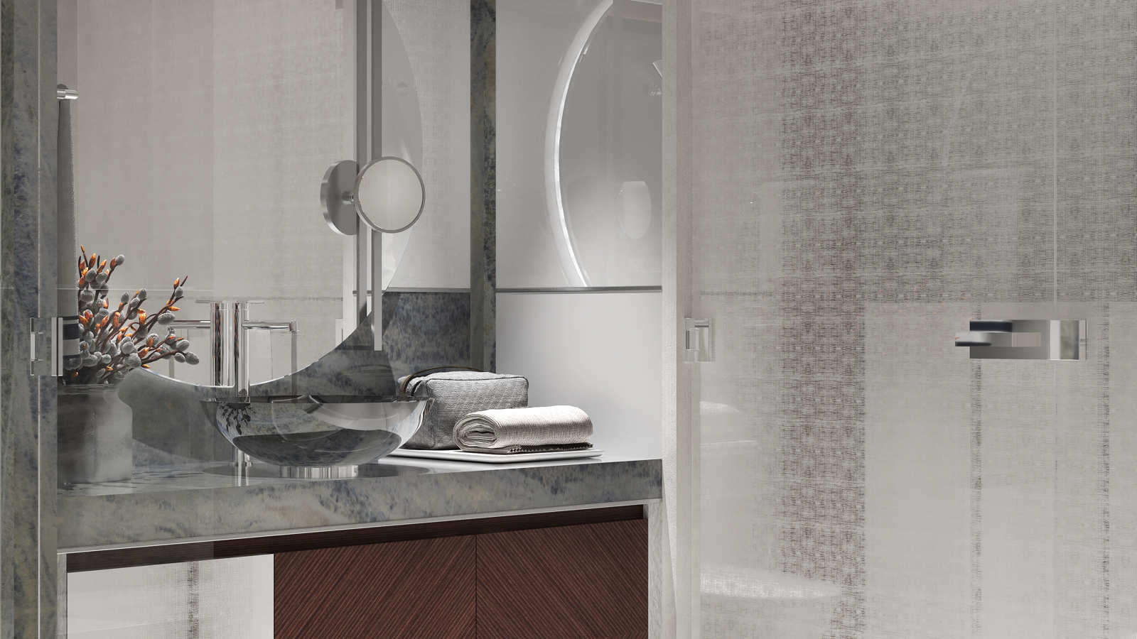 Contemporary bathroom vanity with a glass vessel sink, chrome faucet, and round mirror, accompanied by decorative branches and towels, set against a textured wall background.